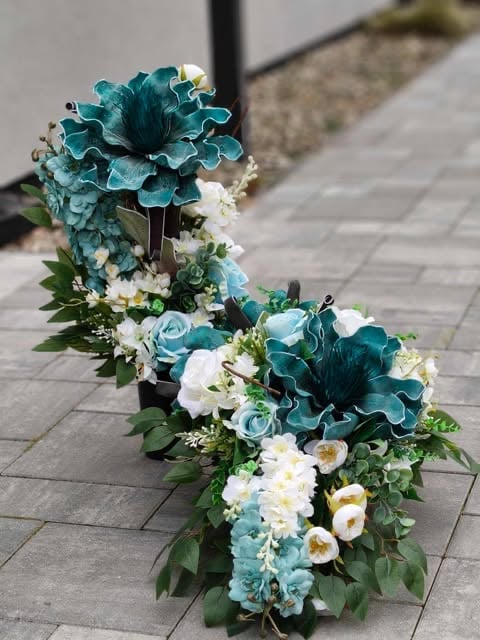 Teal and white floral arrangement with large blooms displayed on a stone pathway
