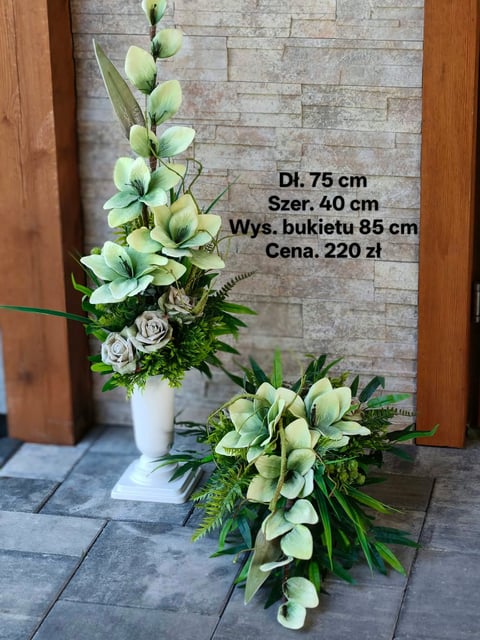 Floral arrangements display: tall white vase with green orchids, roses and foliage on tiled floor next to a horizontal arrangement